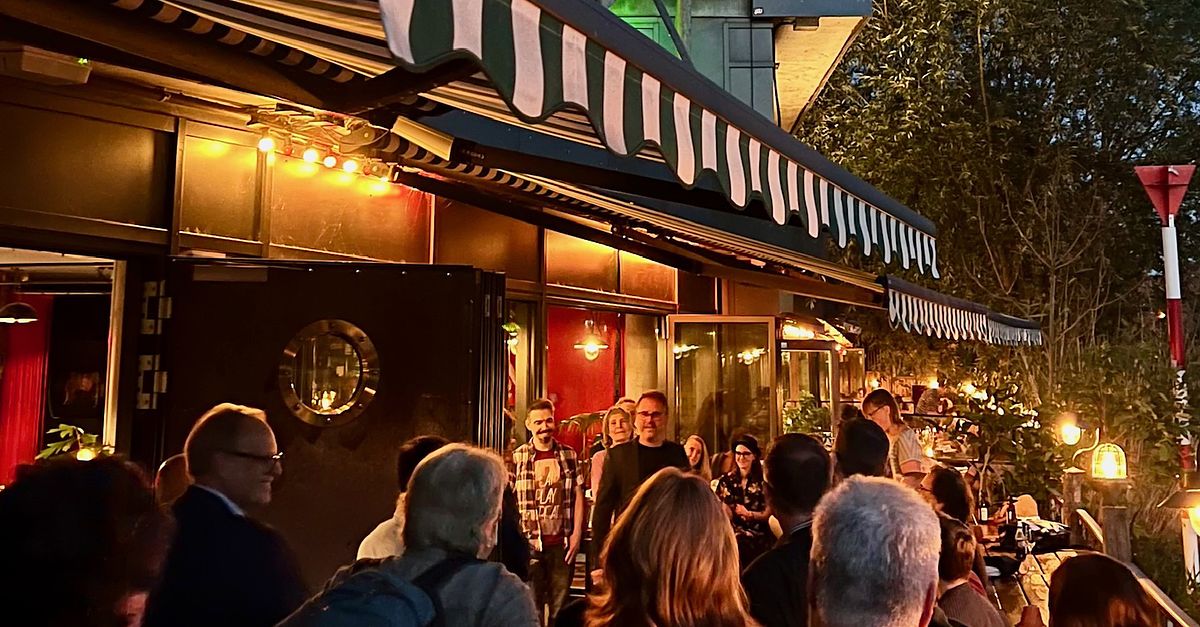 Gäste des #BR26 Vorabend Warm-Up vor dem Restaurant Katerschmaus am Berliner Holzmarkt, abends bei Lichterketten